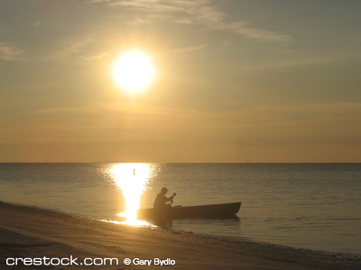 Fisherman in boat at sunrise